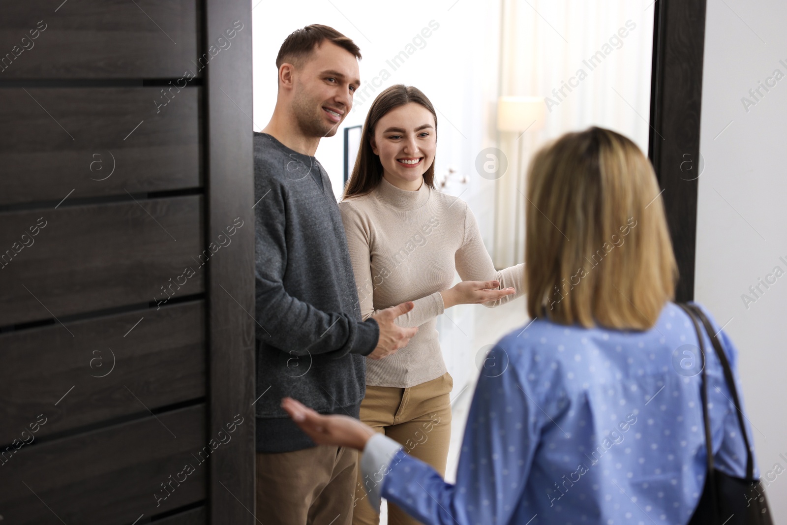 Photo of Lovely couple welcoming friend to their apartment