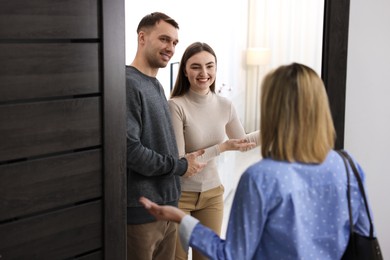 Photo of Lovely couple welcoming friend to their apartment