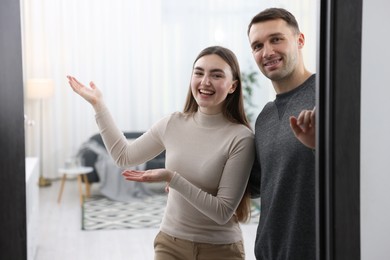 Photo of Happy couple welcoming friends to their apartment