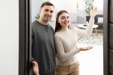 Happy couple welcoming friends to their apartment