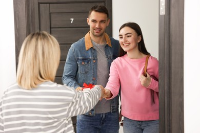 Photo of Woman welcoming new neighbors to her apartment