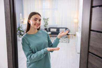 Cheerful woman welcoming guests to her apartment