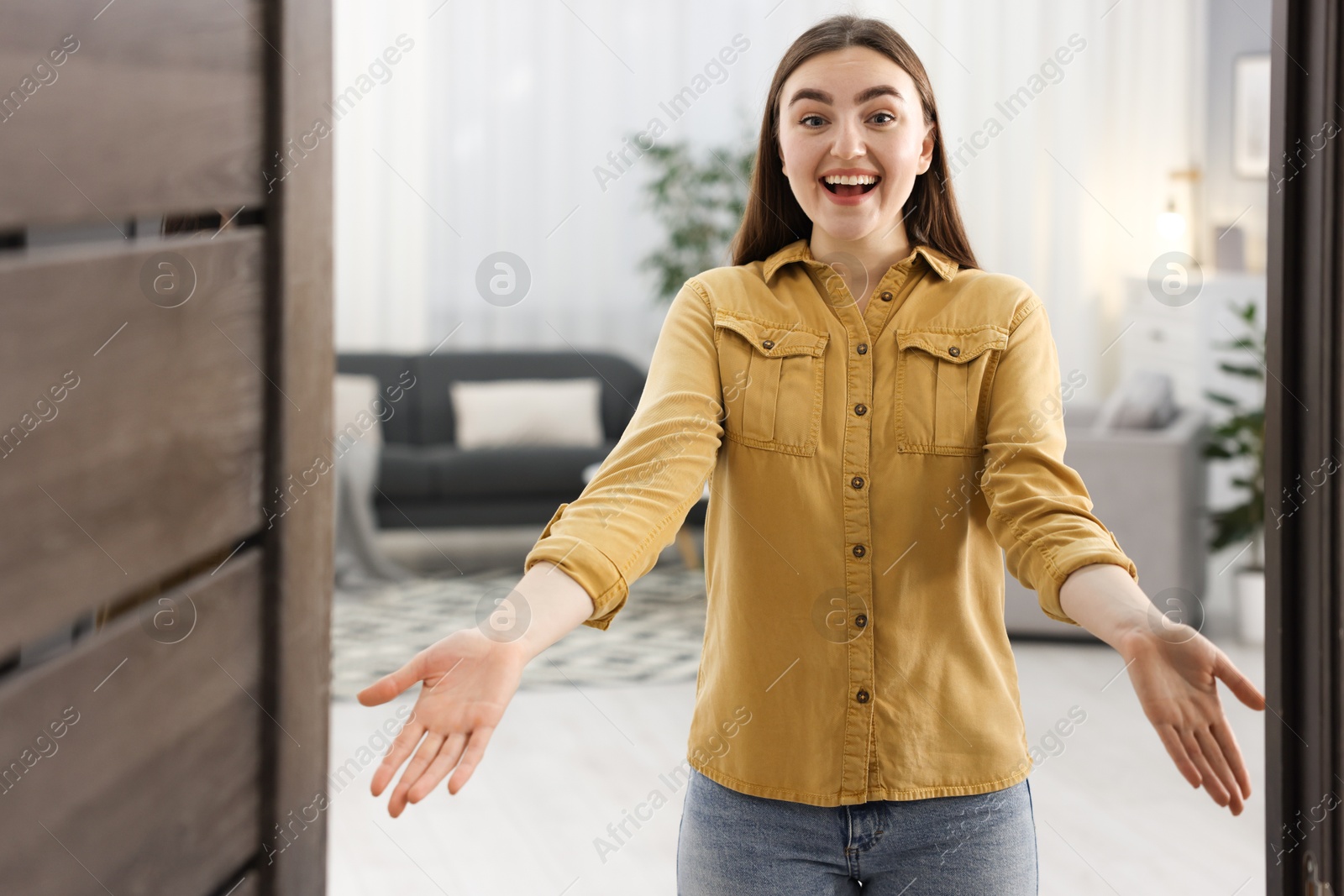 Photo of Happy woman welcoming friend to her house