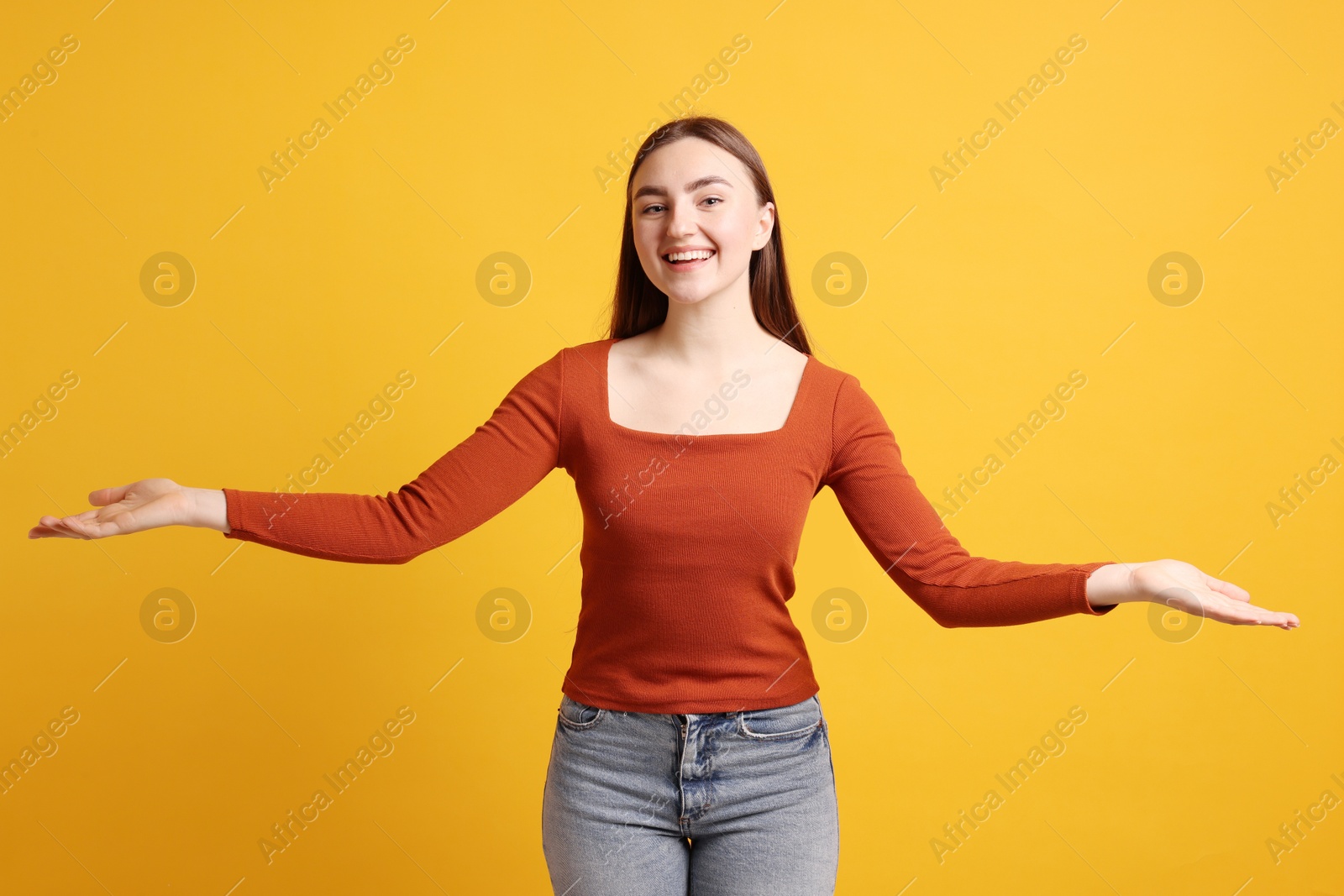 Photo of Happy woman welcoming guests on orange background