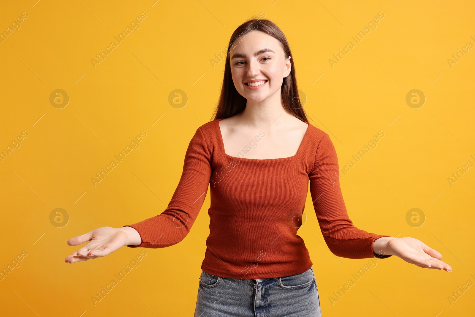 Photo of Happy woman welcoming guests on orange background