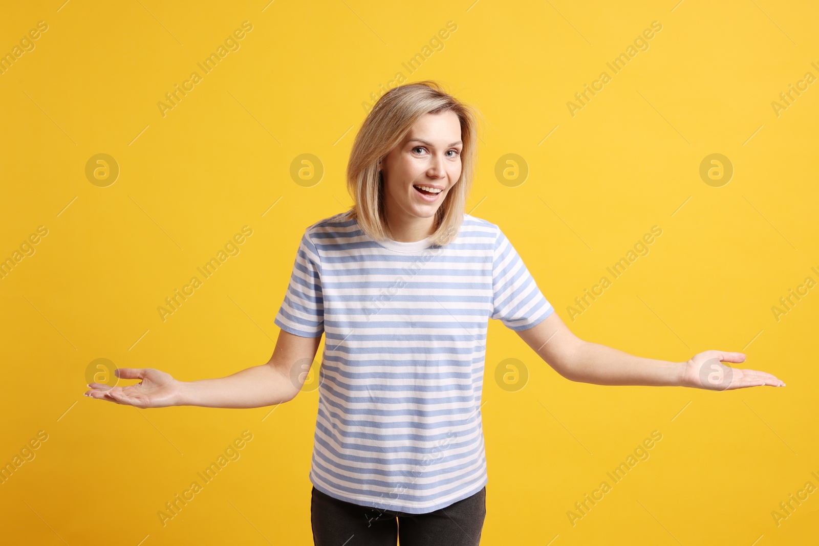 Photo of Happy woman welcoming guests on orange background