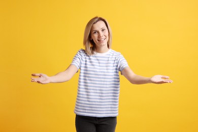 Photo of Happy woman welcoming guests on orange background