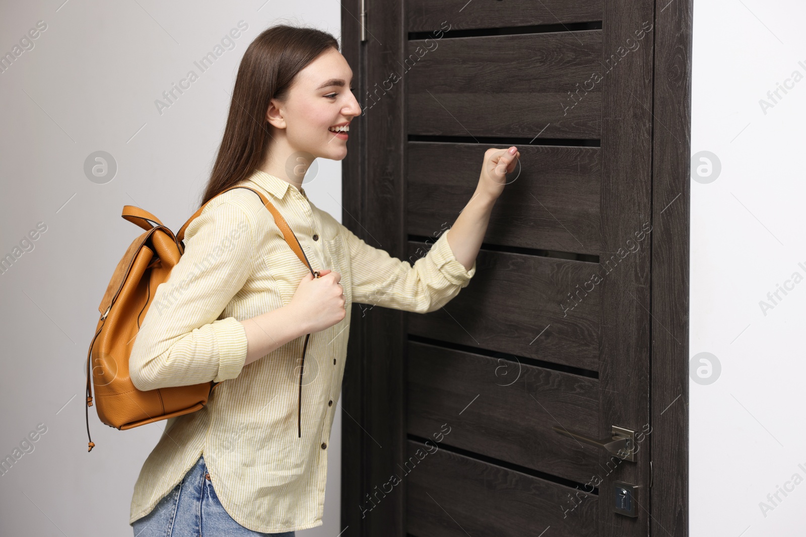 Photo of Woman knocking on door of her friends apartment