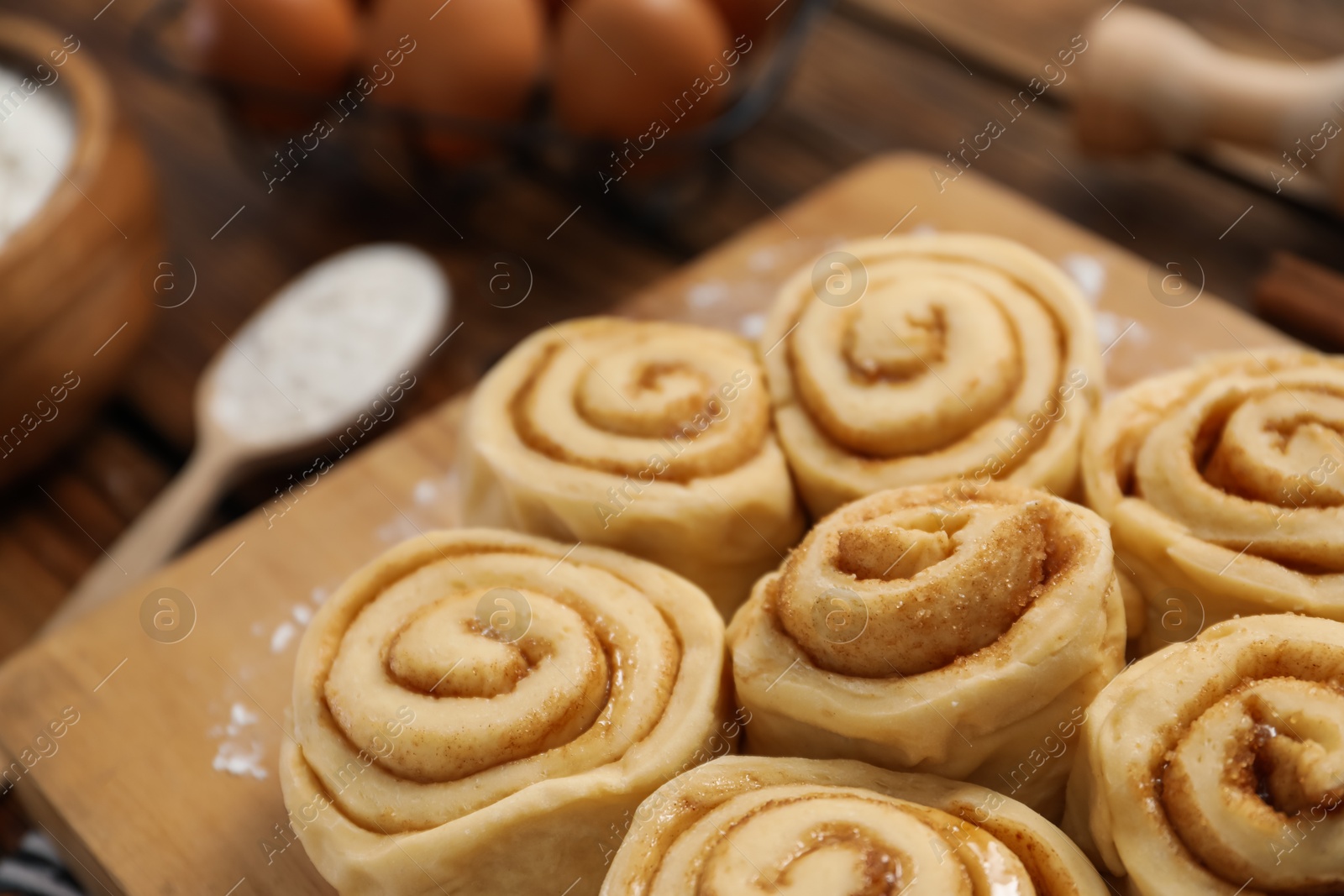 Photo of Many raw cinnamon rolls on table, closeup