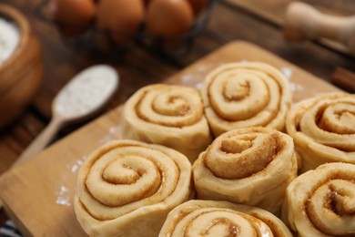 Many raw cinnamon rolls on table, closeup