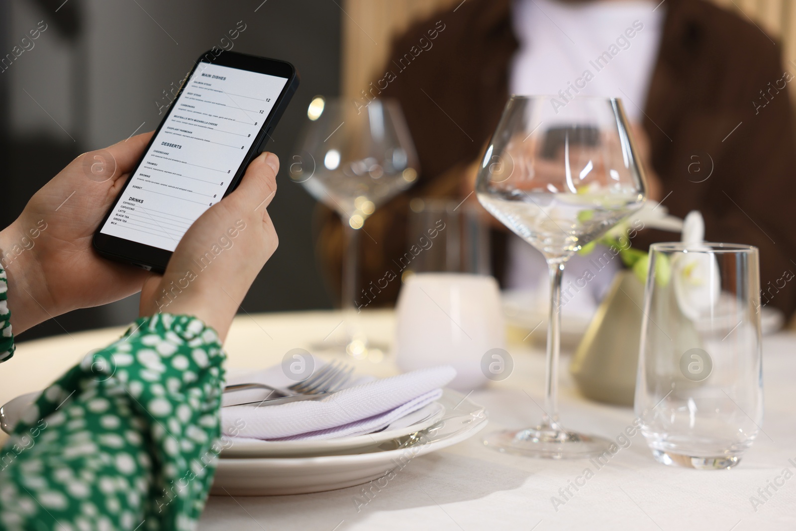 Photo of Couple choosing dishes from digital menu at restaurant, closeup