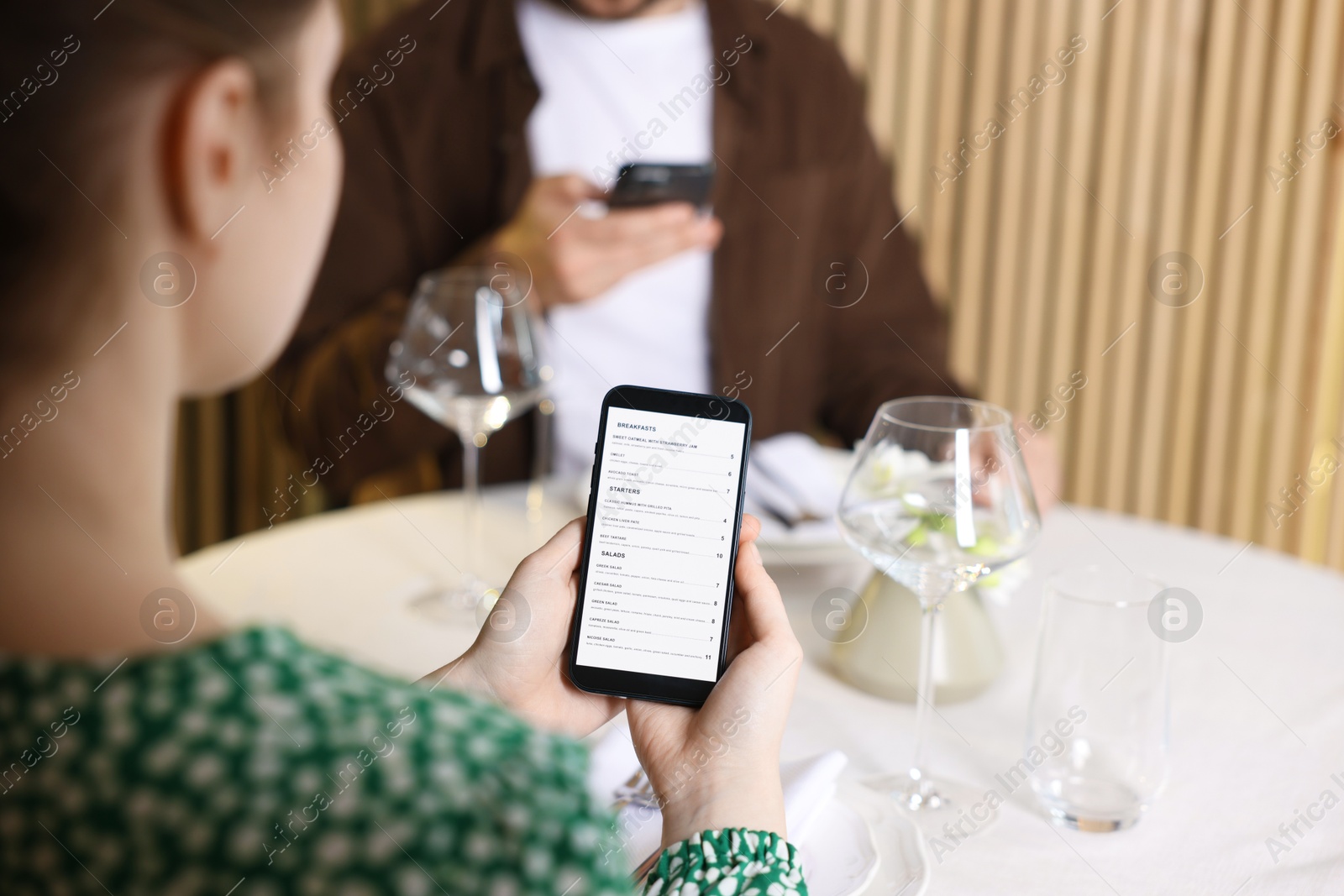 Photo of Couple choosing dishes from digital menu at restaurant, closeup