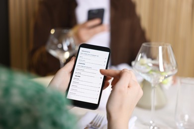 Photo of Couple choosing dishes from digital menu at restaurant, closeup