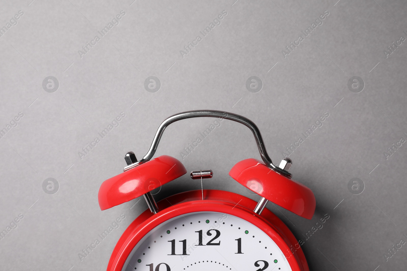 Photo of Red alarm clock on grey background, top view