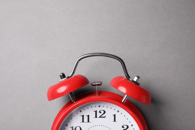Photo of Red alarm clock on grey background, top view