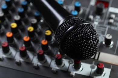 Photo of Professional mixing console with microphone, closeup. Radio studio equipment