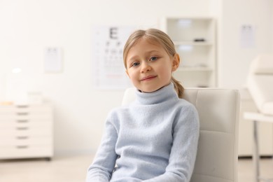 Photo of Little girl at ophthalmologist office, space for text. Eye examination