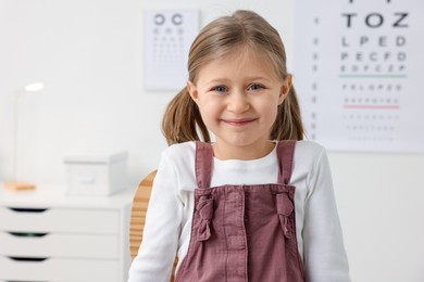 Photo of Portrait of little girl at ophthalmologist office. Eye examination