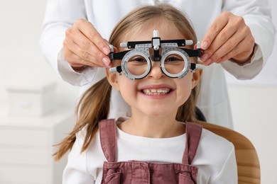 Photo of Ophthalmologist examining patient's vision with trial frame in clinic, closeup