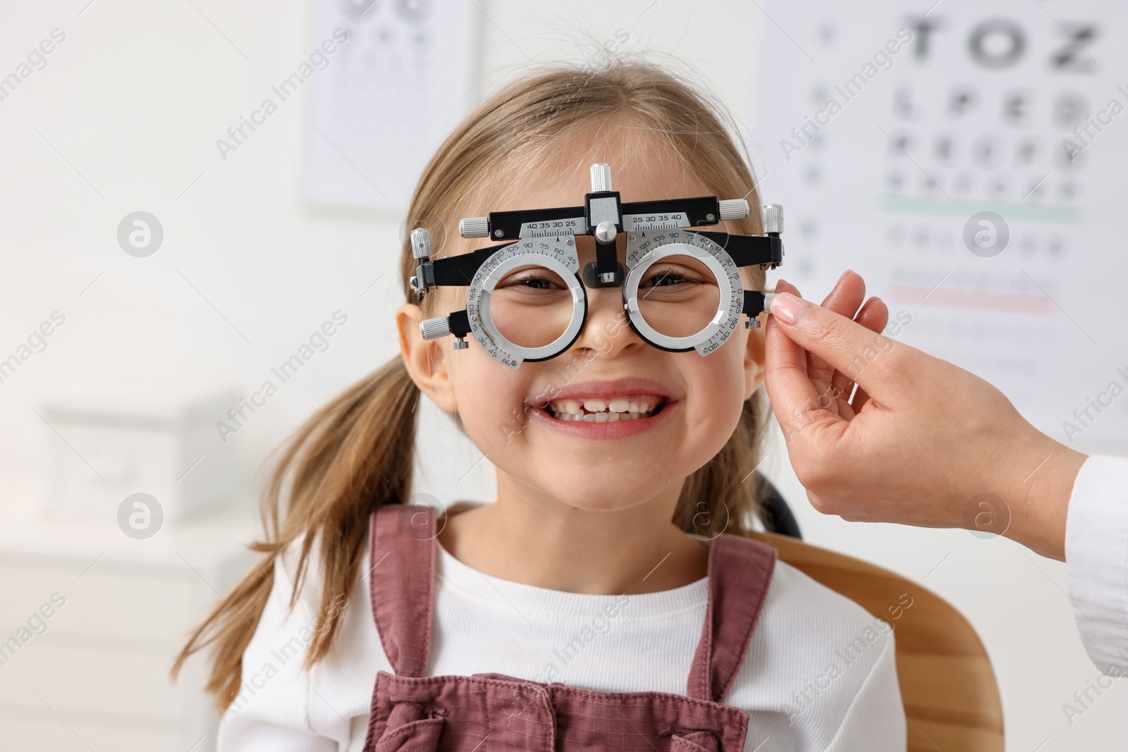 Photo of Ophthalmologist examining patient's vision with trial frame in clinic, closeup