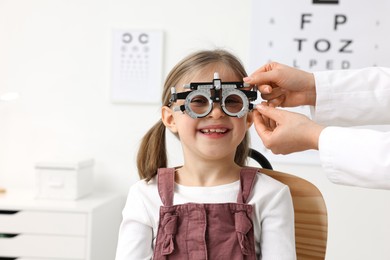 Photo of Ophthalmologist examining patient's vision with trial frame in clinic, closeup