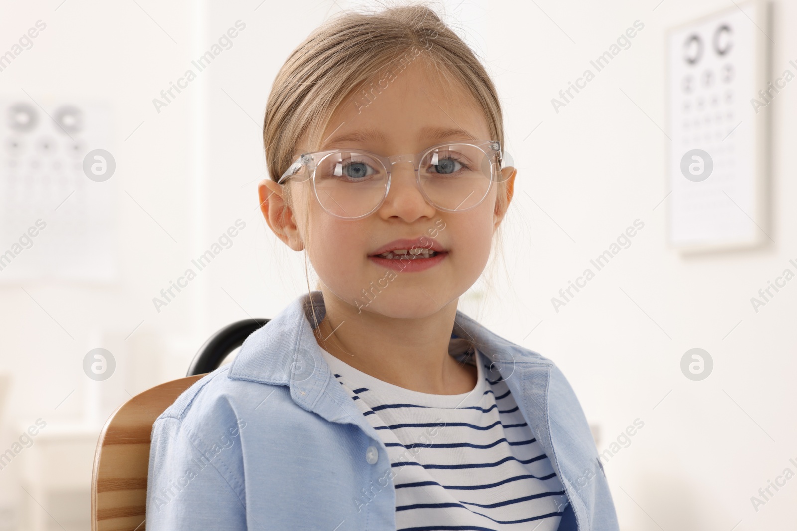 Photo of Little girl trying glasses at ophthalmologist office