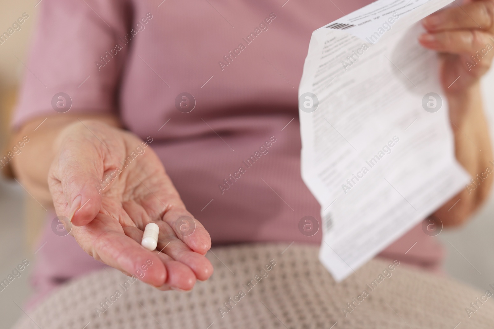 Photo of Senior woman with medical instruction and pill, closeup