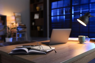 Photo of Workspace with laptop on wooden desk in home office, selective focus. Space for text