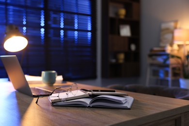 Photo of Workspace with laptop on wooden desk in home office, selective focus. Space for text