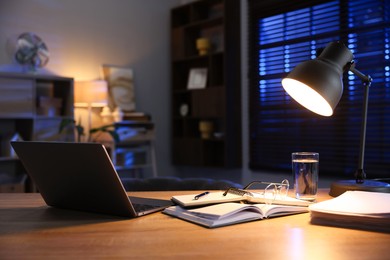 Photo of Workspace with laptop on wooden desk in home office. Space for text