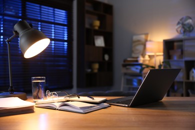 Photo of Workspace with laptop on wooden desk in home office. Space for text