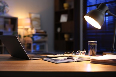 Photo of Workspace with laptop on wooden desk in home office. Space for text