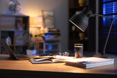 Photo of Workspace with laptop on wooden desk in home office. Space for text