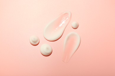 Photo of Cream samples on pink background, top view. Skincare product