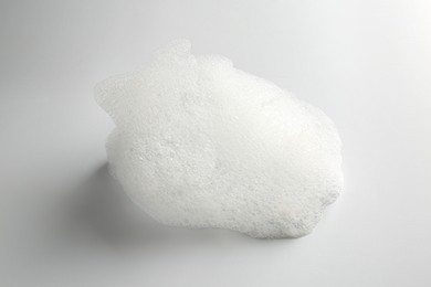 Photo of Detergent foam with bubbles on white background, closeup