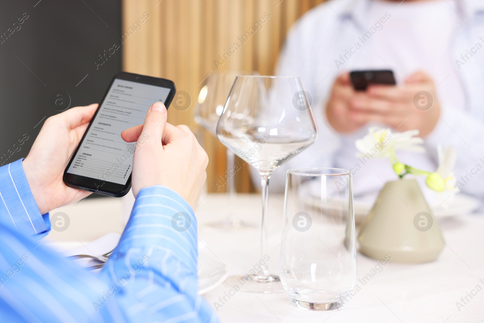 Photo of Couple choosing dishes from digital menu at restaurant, closeup