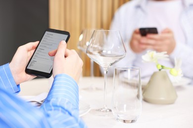 Photo of Couple choosing dishes from digital menu at restaurant, closeup