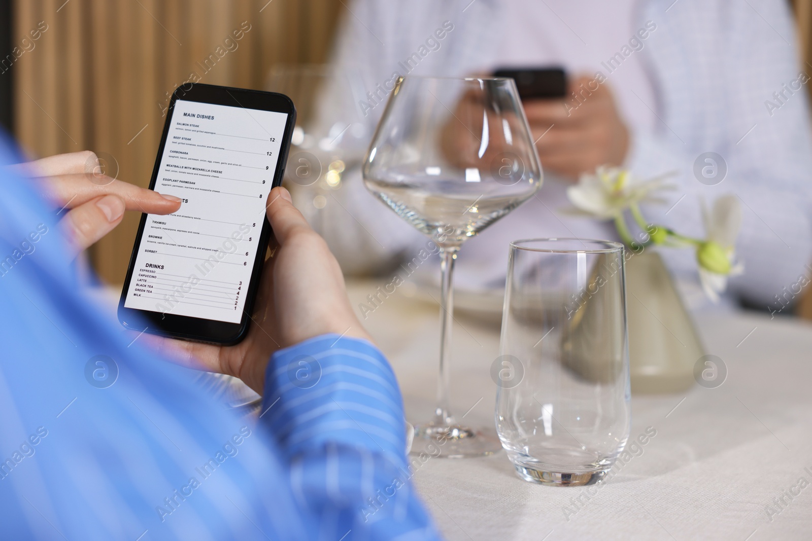 Photo of Couple choosing dishes from digital menu at restaurant, closeup