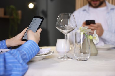 Photo of Couple choosing dishes from digital menu at restaurant, closeup