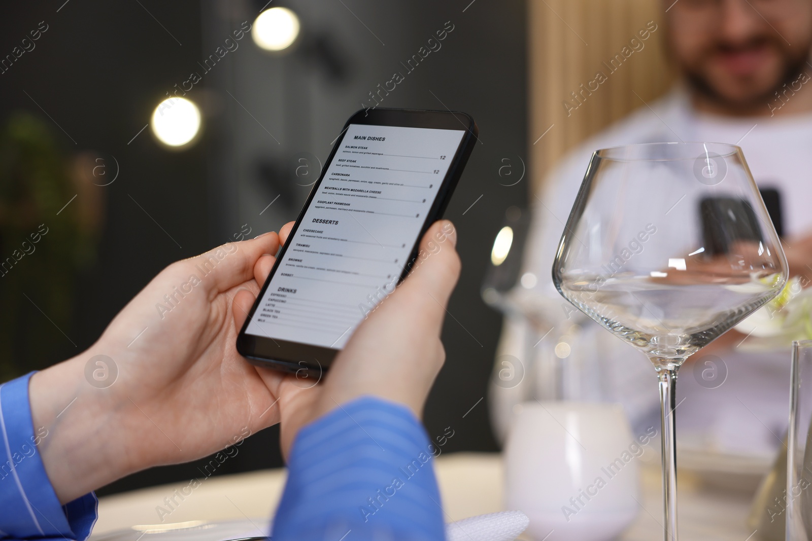 Photo of Couple choosing dishes from digital menu at restaurant, closeup