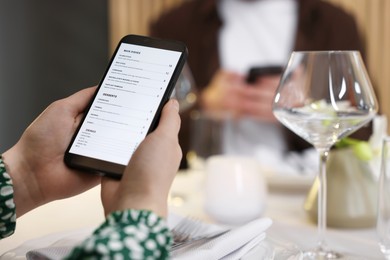 Photo of Couple choosing dishes from digital menu at restaurant, closeup