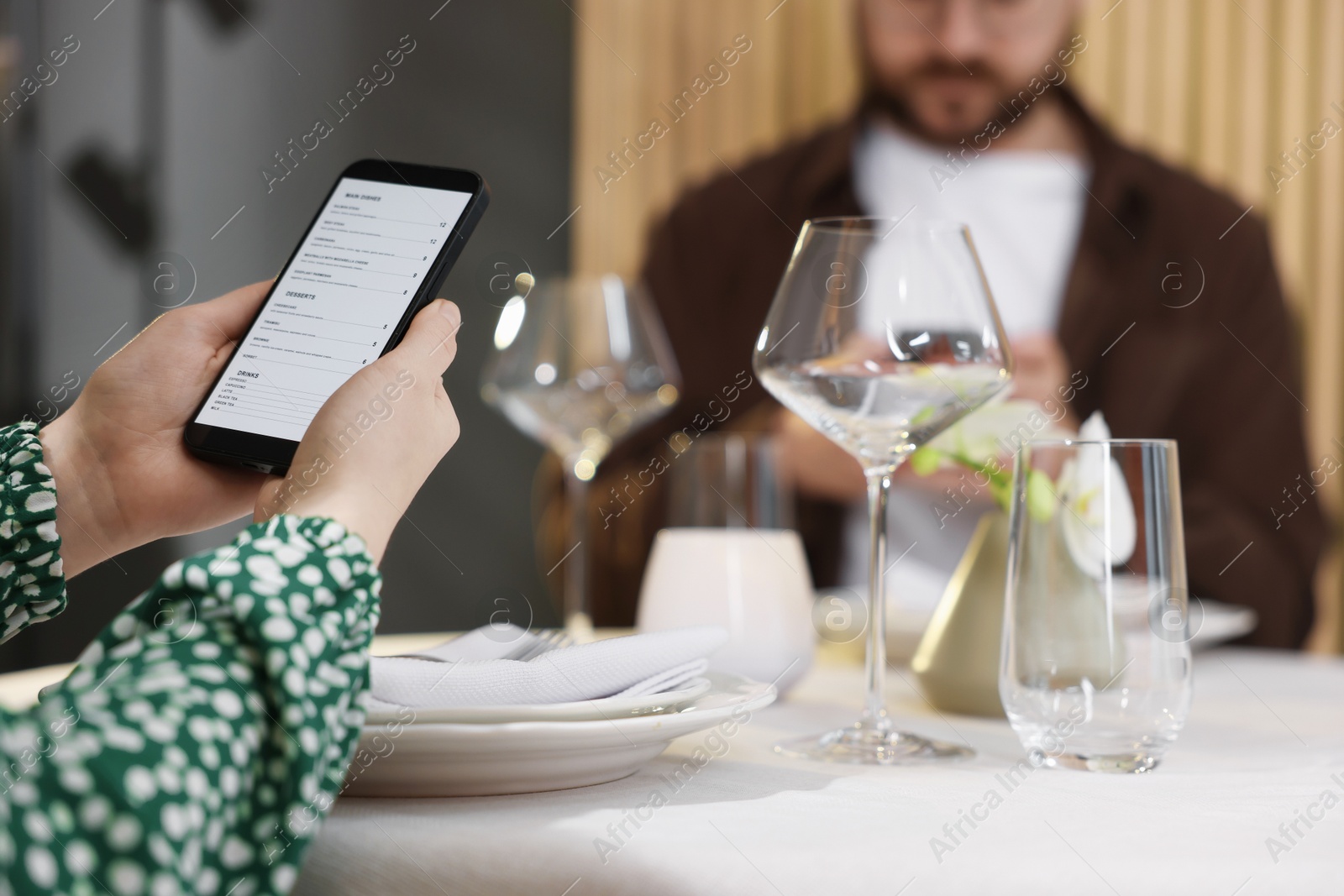 Photo of Couple choosing dishes from digital menu at restaurant, closeup