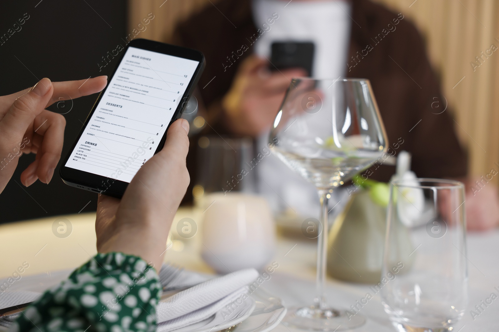 Photo of Couple choosing dishes from digital menu at restaurant, closeup