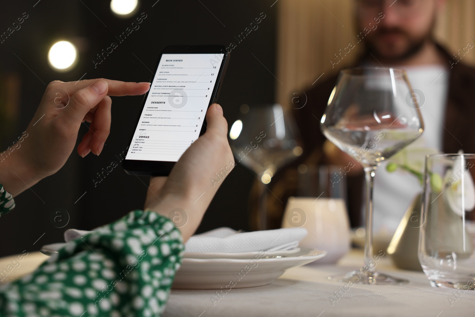 Photo of Couple choosing dishes from digital menu at restaurant, closeup