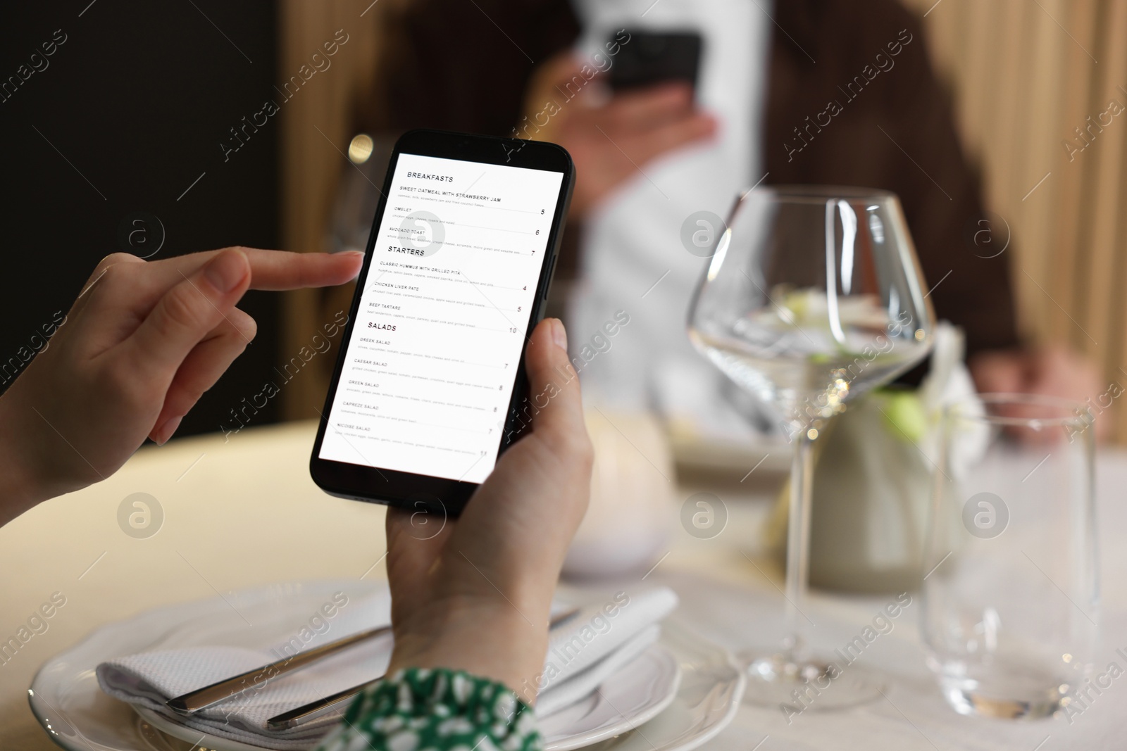 Photo of Couple choosing dishes from digital menu at restaurant, closeup