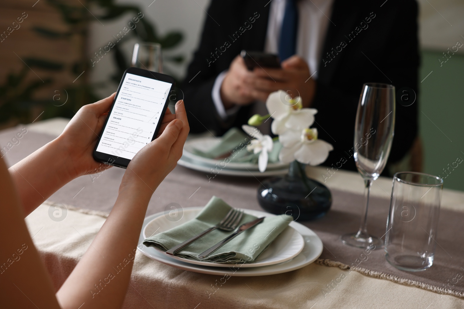 Photo of Couple choosing dishes from digital menu at restaurant, closeup