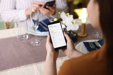 Photo of Couple choosing dishes from digital menu at restaurant, closeup