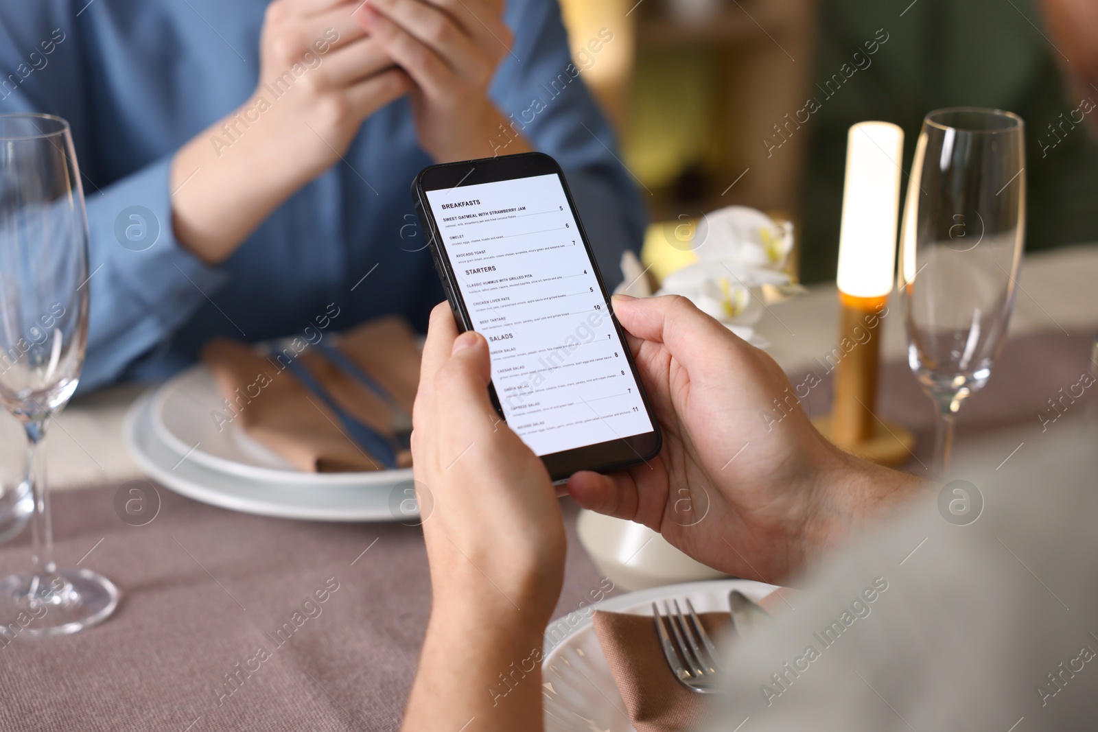 Photo of Couple choosing dishes from digital menu at restaurant, closeup