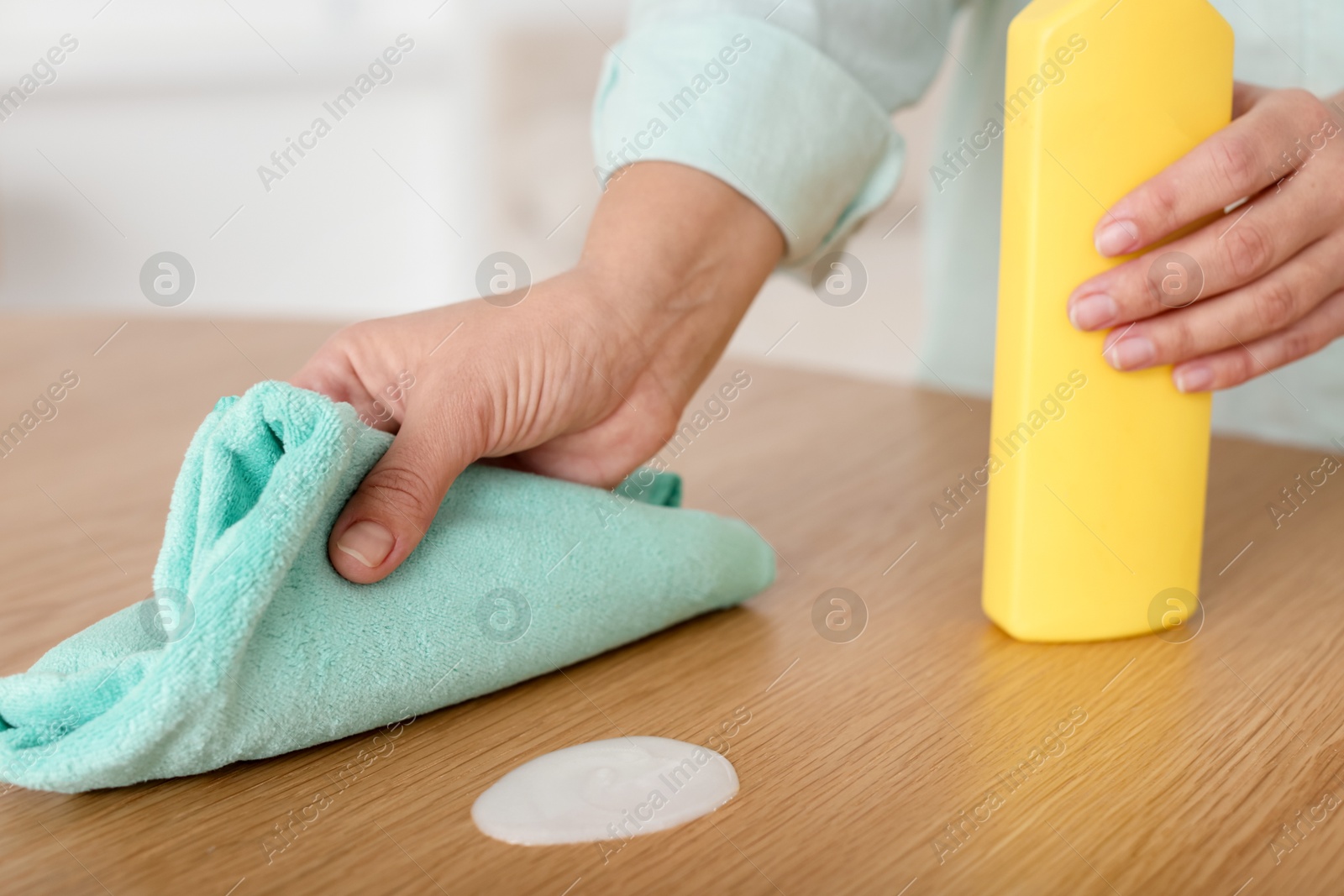 Photo of Woman polishing wooden table at home, closeup