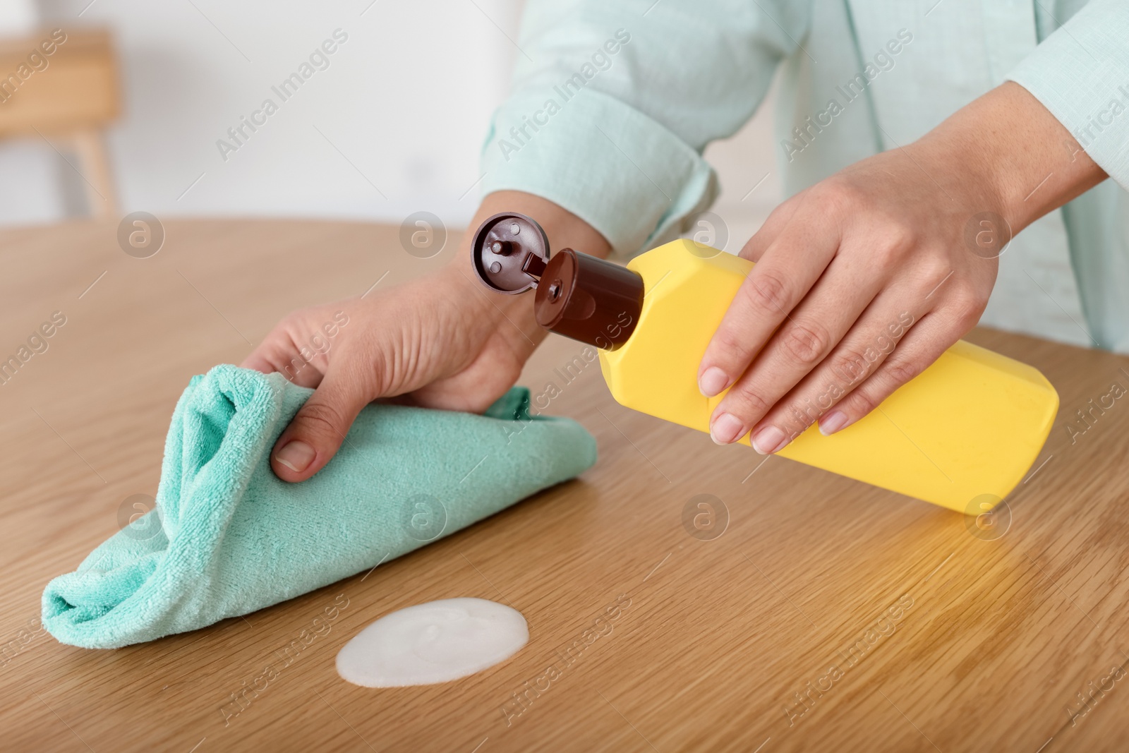 Photo of Woman polishing wooden table at home, closeup